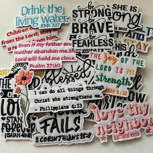 May include: A collection of embroidered patches with inspirational quotes and Bible verses. The patches feature various colors and fonts, with phrases like "Be Strong," "Drink the Living Water," and "Love Thy Neighbor." Some patches include floral and star designs.