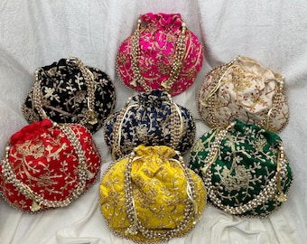 Puede incluir: Siete bolsitas de cordón bordadas en varios colores, incluyendo rojo, rosa, amarillo, verde, crema, negro y azul marino. Cada bolsita presenta un diseño floral y está adornada con un borla de cuentas.