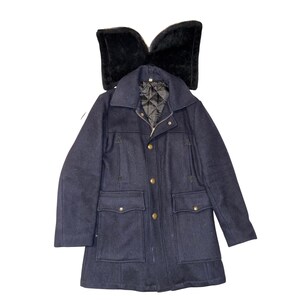 May include: A navy blue coat with a black fur collar. The coat has a button-up front, two chest pockets, and two lower pockets. The coat has a quilted lining and gold-colored buttons.