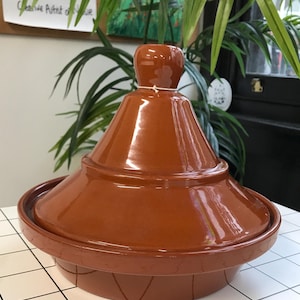 May include: A terracotta tagine with a domed lid. The tagine is a traditional Moroccan cooking pot.