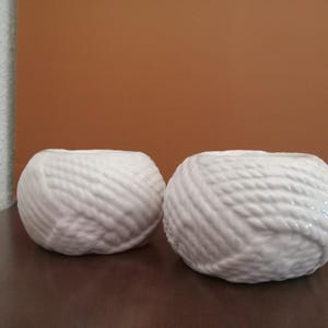 May include: Two white ceramic yarn ball shaped candle holders.