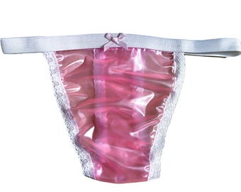 May include: Pink satin lingerie with white lace trim and a pink bow. The lingerie has a white elastic waistband.