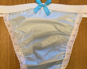 May include: Light blue satin underwear with white lace trim and a light blue bow at the centre front.
