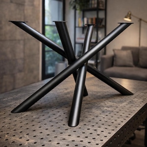 Op de afbeelding: Zwart metalen tafelonderstel met een uniek, geometrisch ontwerp. De basis heeft meerdere schuine poten die elkaar kruisen in het midden, waardoor een moderne en industriële uitstraling ontstaat. De poten zijn bevestigd aan een donker, getextureerd tafelblad.
