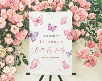 May include: A white sign with a pink and purple butterfly theme. The sign says "Welcome to Lillianna's Butterfly Party" and "Saturday, June 23, 2023".