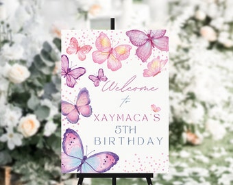 May include: Welcome to Xaymaca's 5th Birthday sign with a pink and purple butterfly design on a white background with pink and white confetti.