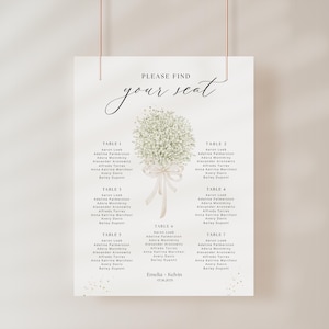 May include: A white wedding seating plan with the words "PLEASE FIND your seat" in cursive. The chart has a floral design and lists guest names under table numbers. The names are in black font. The wedding date is also included.