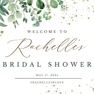 May include: A white bridal shower invitation with green watercolor leaves and gold glitter. The text reads "Welcome to Rachelle's Bridal Shower May 17, 2035 #RachelleInLove"