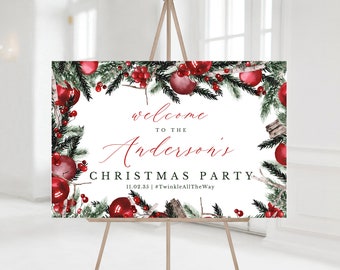 May include: A rectangular Christmas party sign on an easel. The sign features a watercolor design with red ornaments, berries, and evergreen branches. The text reads "welcome to the Anderson's Christmas Party" with the date and a hashtag.