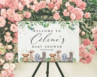 May include: Welcome to Celine's Baby Shower sign with a white background, gold glitter, green leaves, and a watercolor illustration of a giraffe, lion, elephant, and zebra. The sign also includes the date August 14, 2022.