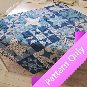 May include: A blue and white quilt with a star pattern. The quilt features various shades of blue fabric, including solid and patterned designs. The quilt is rectangular and appears to be handmade.