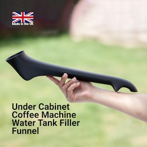 May include: Black plastic funnel for filling a coffee machine water tank. The funnel is long and curved, with a wide opening at one end and a narrow spout at the other. The text "Under Cabinet Coffee Machine Water Tank Filler Funnel" is printed below the funnel.