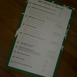 May include: A green checklist with the title "DAILY METHOD FOR Success!" and a list of tasks to complete for personal and professional development. The tasks include "20 Minutes of personal development (reading or audio)", "Gratitude List", "3 NEW Asks", "3 Follow-up from Asks", "3 Client/PC Follow-ups", "3 Team Member connections", "3 Relationship building actions", "Make a social media post", "Review your goals", and "Plan your next 3 priorities for the day".