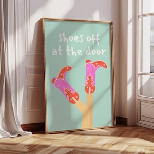 May include: A turquoise blue poster with the text "shoes off at the door" in white. Two pink cowboy boots with orange and white star designs are upside down with the toes pointing up.