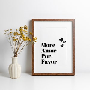 May include: A framed print with a white background and black text that reads "More Amor Por Favor" with three black hearts above the text.
