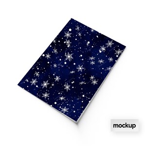 May include: A dark blue sheet of wrapping paper with a white snowflake pattern. The paper is perfect for wrapping gifts for the winter holidays.