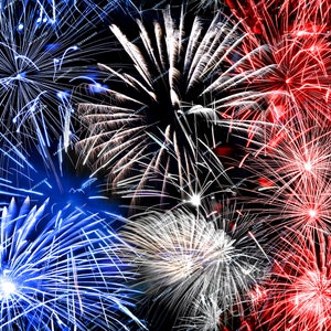 May include: A vibrant display of fireworks exploding in the night sky. The fireworks are red, white, and blue, creating a celebratory and patriotic atmosphere.