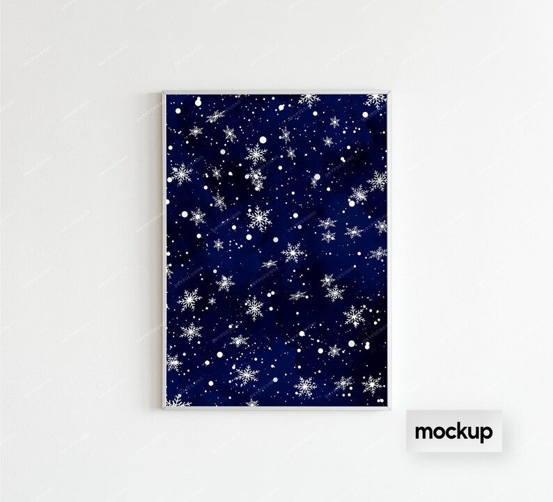 May include: A framed print with a dark blue background and a white snowflake pattern. The print is in a silver frame and is hanging on a white wall.