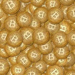 May include: A close-up image of a pile of gold-colored coins with the letter "B" on each coin. The coins are arranged in a random pattern.