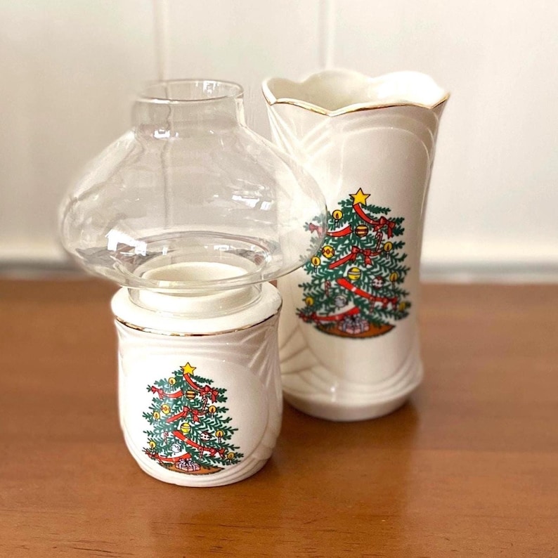Holiday Hurricane Candle Holder & Matching Vase- Christmas Tree Motif- Vintage Ron Gordon Designs, Gold Trim Porcelain in Original Boxes Height of each: approx 6.5"
Width of Vase: 3"
off white background with colorful lit green spruce or long needle Christmas tree pattern with yellow star on the top