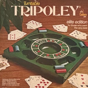 May include: A green square Tripoley board game with a central circular track labeled Kitty, Jack, Queen, King, and King-Queen. The board features red and blue plastic chips, scattered playing cards, and the text Turntable Tripoley Elite Edition.