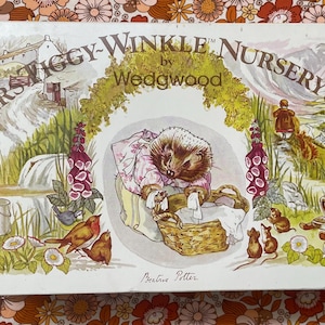 Puede incluir: Una caja vintage del juego de guardería Mrs. Tiggy-Winkle de Wedgwood, con una ilustración de un erizo lavando la ropa. La caja tiene un fondo crema con una colorida ilustración de una escena campestre con flores, pájaros y ratones.