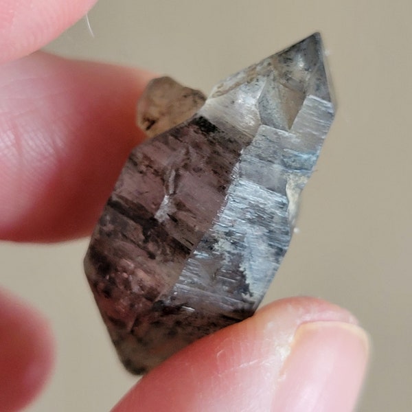 Double terminated Tibetan black phantom quartz point with rainbows- skeletal formation- carbon inclusions- key imprint
