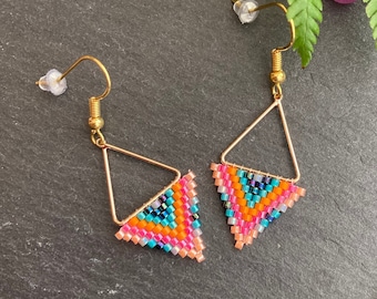 May include: A pair of gold triangle earrings with colorful beaded fringe. The fringe is made of pink, orange, blue, and turquoise beads.