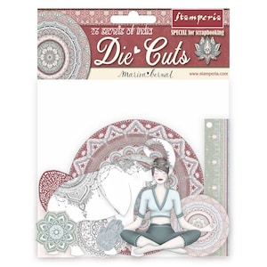 May include: Die-cut paper craft set featuring a woman meditating with an elephant. The set includes intricate mandala designs in shades of pink, red, and green. The title "26 secrets of india Die-Cuts Marisa Bernal" is printed on the packaging.