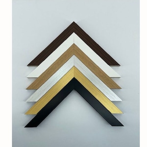 May include: A set of six picture frames in various colours, including black, gold, silver, brown, and white. The frames are arranged in a pyramid shape, with the largest frame at the bottom and the smallest frame at the top.