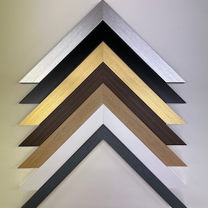 K&ouml;nnte beinhalten: Nahaufnahme von sechs verschiedenen Bilderrahmenecken, jede mit einer anderen Farbe und Oberfl&auml;che. Die Farben sind Silber, Schwarz, Gold, Braun, Naturholz und Wei&szlig;.