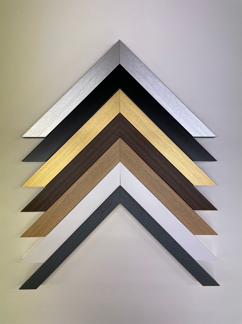 K&ouml;nnte beinhalten: Nahaufnahme von sechs verschiedenen Bilderrahmenecken, jede mit einer anderen Farbe und Oberfl&auml;che. Die Farben sind Silber, Schwarz, Gold, Braun, Naturholz und Wei&szlig;.