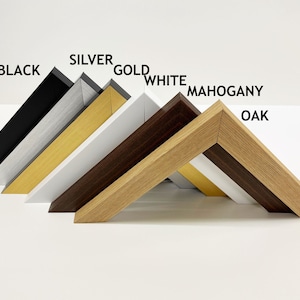 May include: Close-up of six picture frames in different colors, including black, silver, gold, white, mahogany, and oak. The frames are arranged in a row, with the black frame at the top and the oak frame at the bottom.