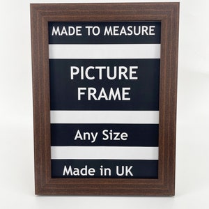 May include: A brown wood picture frame with white text that reads "Made to Measure Picture Frame Any Size Made in UK".