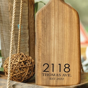 Peut inclure: Une planche à découper en bois avec un design d'antenne de cerf. La planche est gravée avec l'adresse "2118 Thomas Ave. Est 2022".