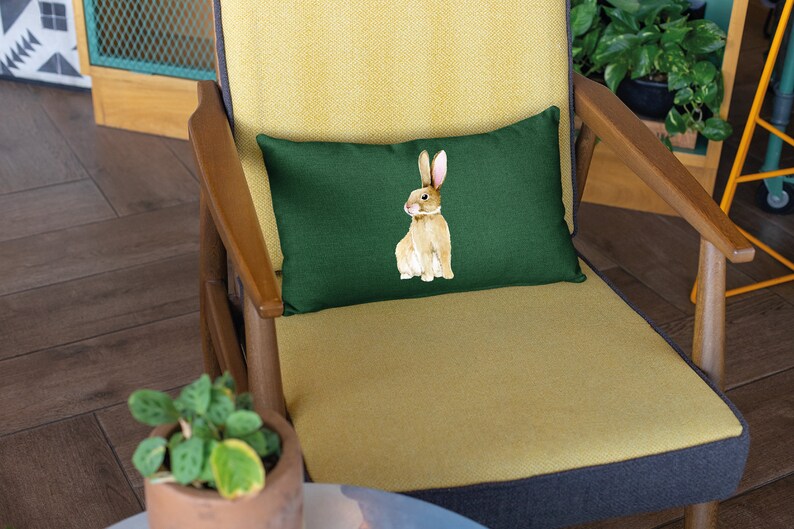 May include: A green cushion with a brown rabbit illustration on a yellow armchair.