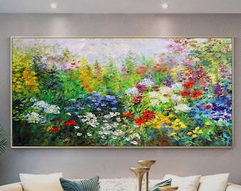 May include: A colorful oil painting depicting a field of wildflowers in various shades of red, yellow, blue, and white. The painting is framed in gold and hangs on a wall in a living room setting.