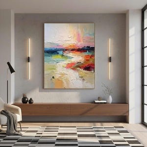 May include: An abstract oil painting with a textured surface, featuring a landscape of blended colors. The artwork showcases hues of blue, green, orange, and red, creating a vibrant and dynamic composition. The painting is displayed above a wooden cabinet.