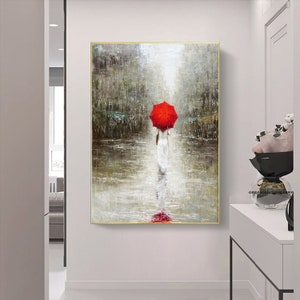 May include: A painting of a woman walking in the rain with a red umbrella. The woman is wearing a white dress and the background is a city street.
