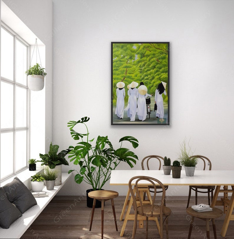 May include: A framed painting depicting four women in white dresses and conical hats walking down a path lined with green trees. The women are walking in a line, with the woman in the back riding a bicycle.