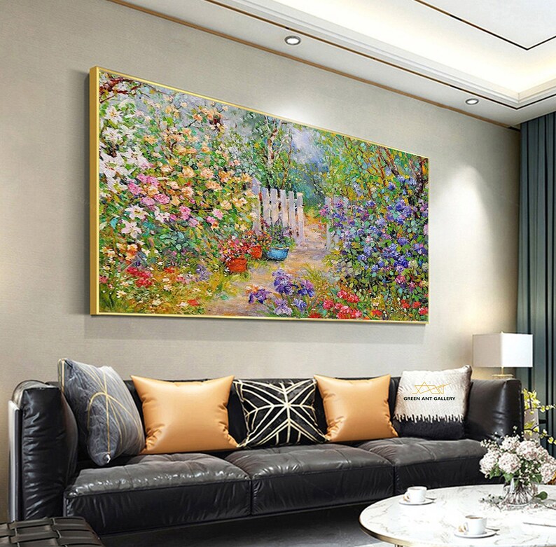 Pode incluir: Uma pintura a &oacute;leo colorida que retrata uma cena de jardim com uma cerca branca de madeira e um caminho que leva atrav&eacute;s de uma variedade de flores. A pintura &eacute; emoldurada em ouro e pendurada em uma parede.