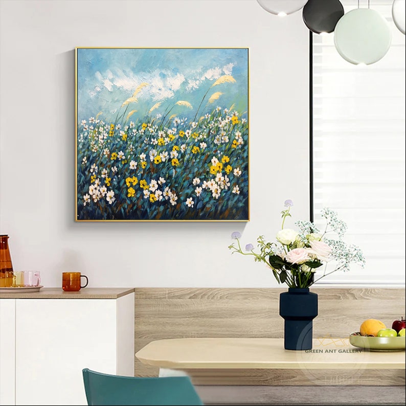 K&ouml;nnte beinhalten: Ein Gem&auml;lde, das ein Feld mit wei&szlig;en und gelben Blumen zeigt, in dem hohes Gras im Wind weht, vor einem blauen Himmel mit wei&szlig;en Wolken.
