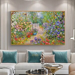 Pode incluir: Uma pintura que representa uma cena de jardim com uma cerca branca de madeira e um caminho que leva atrav&eacute;s das flores. As flores s&atilde;o em tons de rosa, roxo e azul. A pintura &eacute; emoldurada em ouro.
