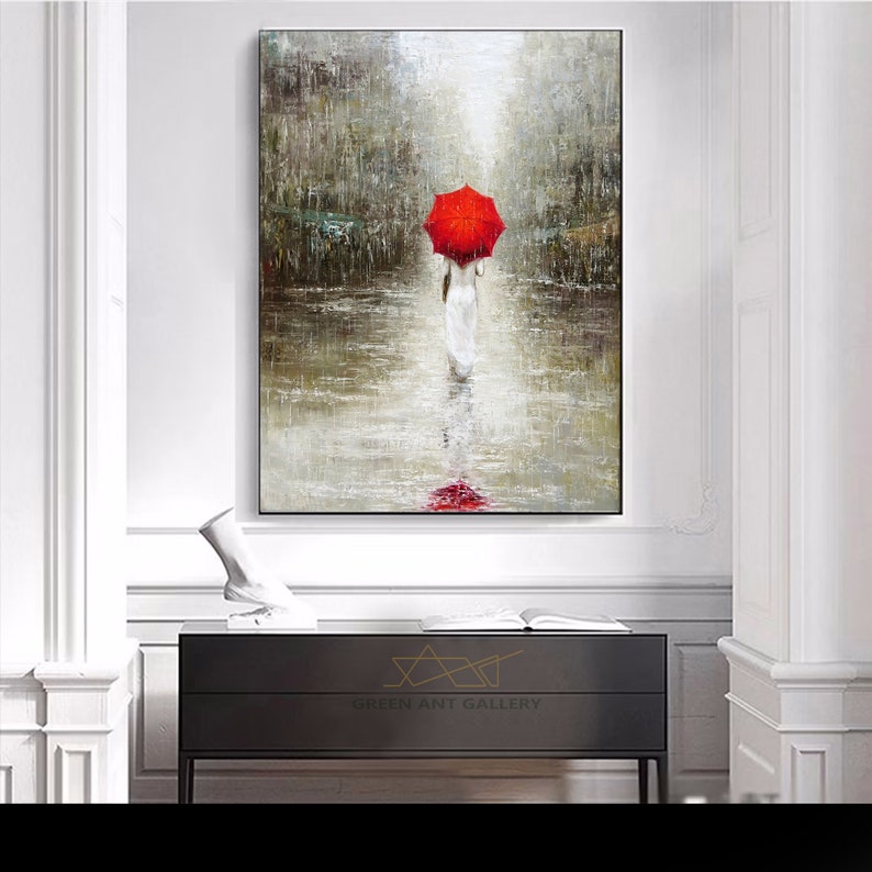 May include: A painting of a woman walking in the rain with a red umbrella. The woman is wearing a white dress and the background is a blurry cityscape.