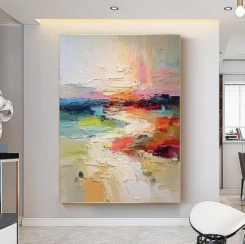 May include: Abstract landscape painting with a gold frame. The artwork features a textured surface with a palette of colors including blue, orange, pink, and yellow. The brushstrokes create a sense of depth and movement, evoking a serene atmosphere.