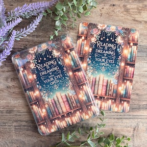 May include: Two rectangular cases with a fantasy bookshelf design. The cases feature a dark blue background with a bookshelf filled with books, fairy lights, and floral accents. The text "Reading is Dreaming with Your Eyes Open" is displayed.