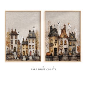 Op de afbeelding: Twee ingelijste wandkunstprints met aquarelillustraties van huizen met meerdere verdiepingen, verlichte ramen, kale herfstbomen en doorschijnende witte geesten die boven de gebouwen zweven. De tekst RARE DIGIT CRAFTS staat eronder.