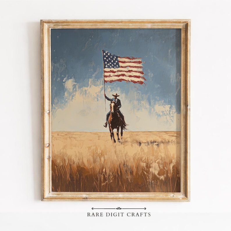 May include: Framed painting of a cowboy on horseback holding a large American flag. The artwork features a blue sky, a field of tall grass, and a gold-colored wooden frame. The text "RARE DIGIT CRAFTS" is at the bottom.