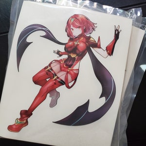 May include: A sticker featuring a female anime character with red hair and a red and black outfit. She is posed with one leg bent and her arms outstretched. The background is white.