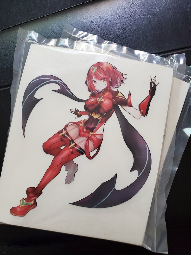 May include: A sticker featuring a female anime character with red hair and a red and black outfit. She is posed with one leg bent and her arms outstretched. The background is white.